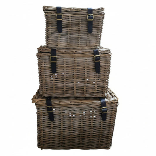 Stack of three wicker baskets with black straps on a white background