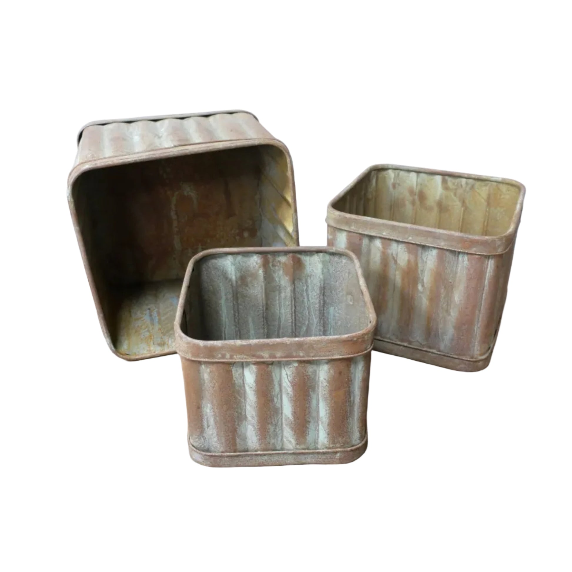 Three rustic metal bins on a wooden surface with a white wall background