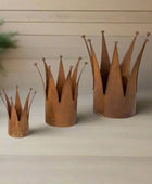 Three rusted metal crowns of different sizes on a white background