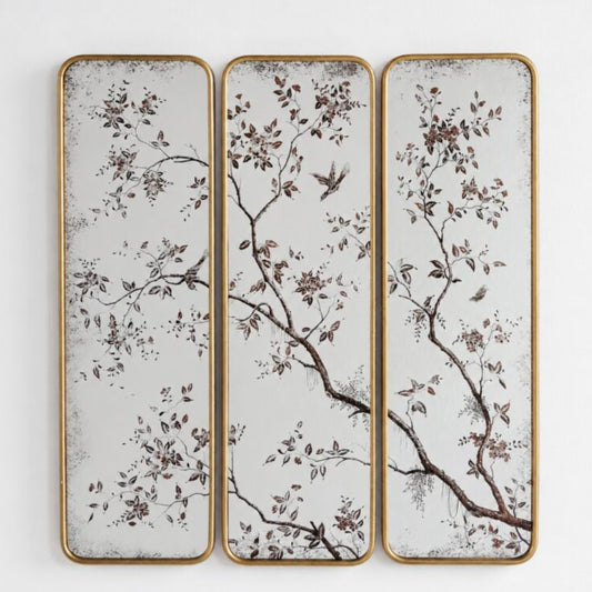 Three vertical rectangular wall panels with a gold-toned frame, featuring a delicate botanical branch and bird pattern in brown and muted tones on a distressed off-white background.