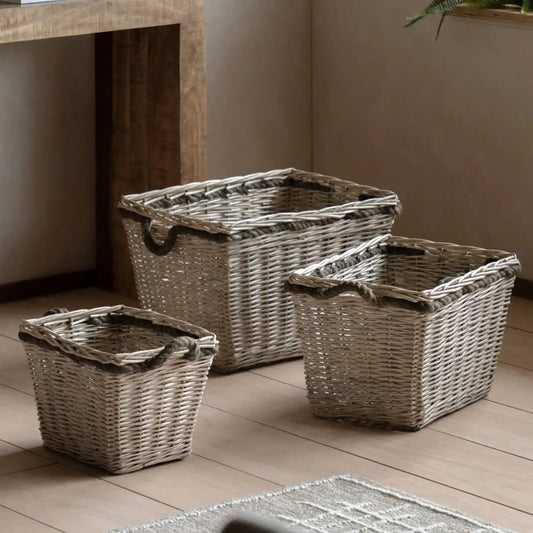 Three woven baskets of different sizes on a wooden floor.