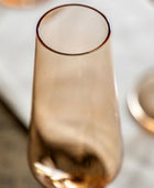Rose gold champagne flute on a marble surface