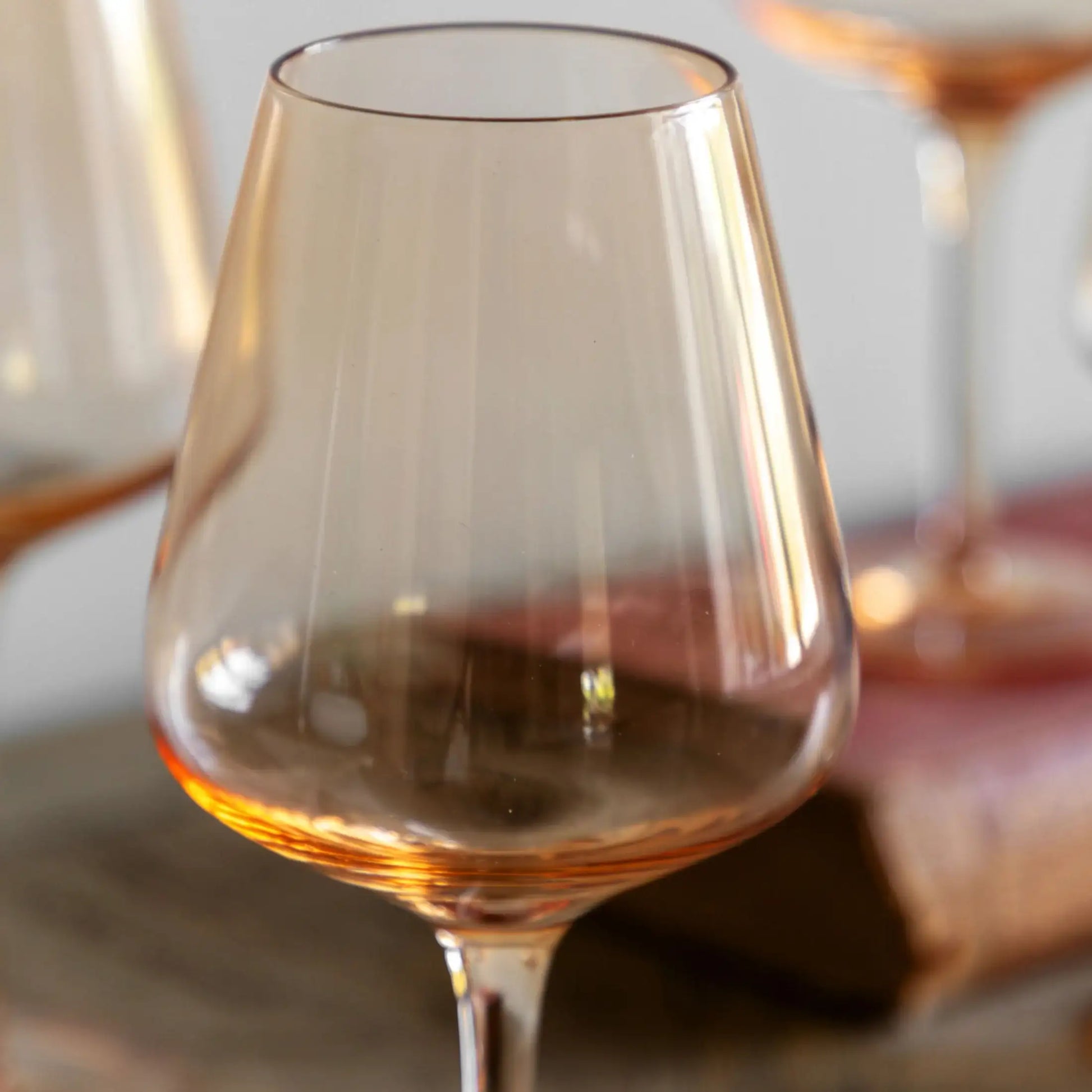 Clear wine glass with a warm tint on a wooden surface