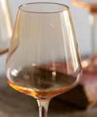 Clear wine glass with a warm tint on a wooden surface