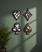 Decorative wall art pieces shaped like playing card suits on a green wall.