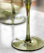 Close-up of a wine glass with white wine on a white surface