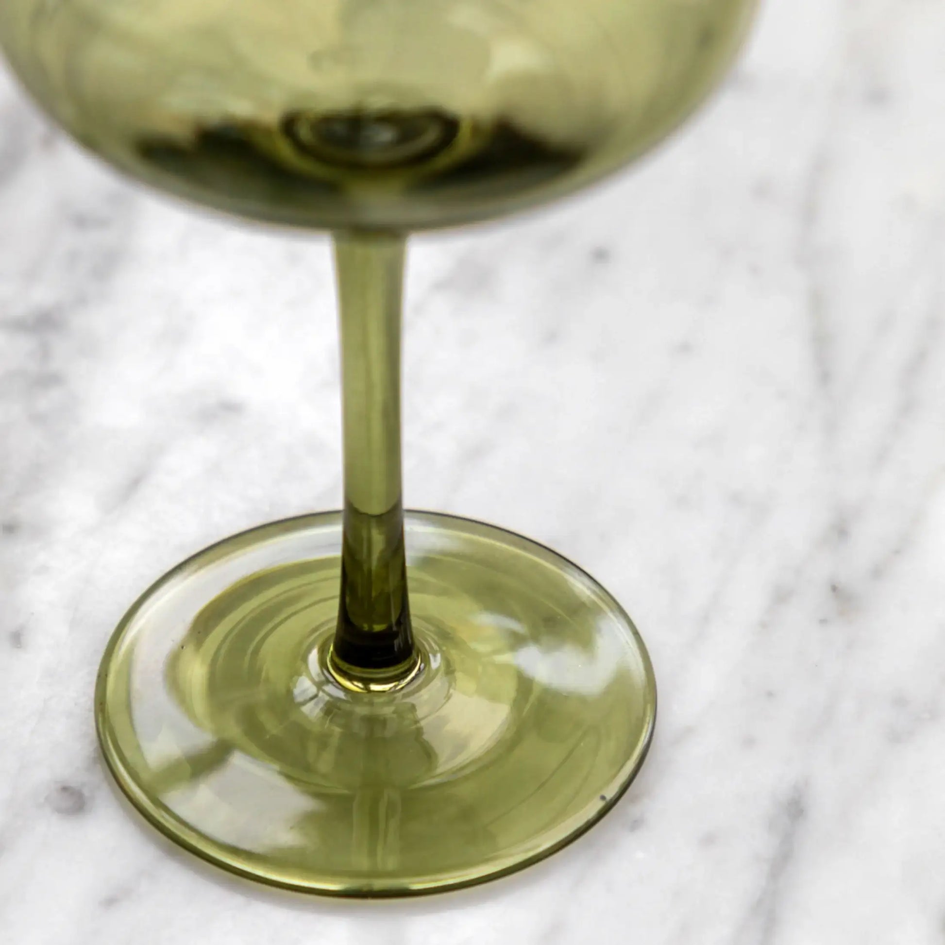 Green glass with liquid on a marble surface