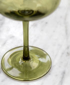 Green glass with liquid on a marble surface