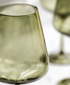 Green glass tumblers on a white surface