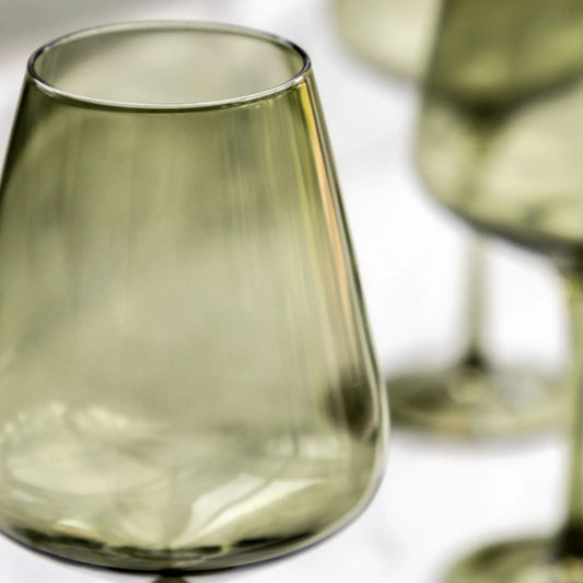 Green glass tumblers on a white surface