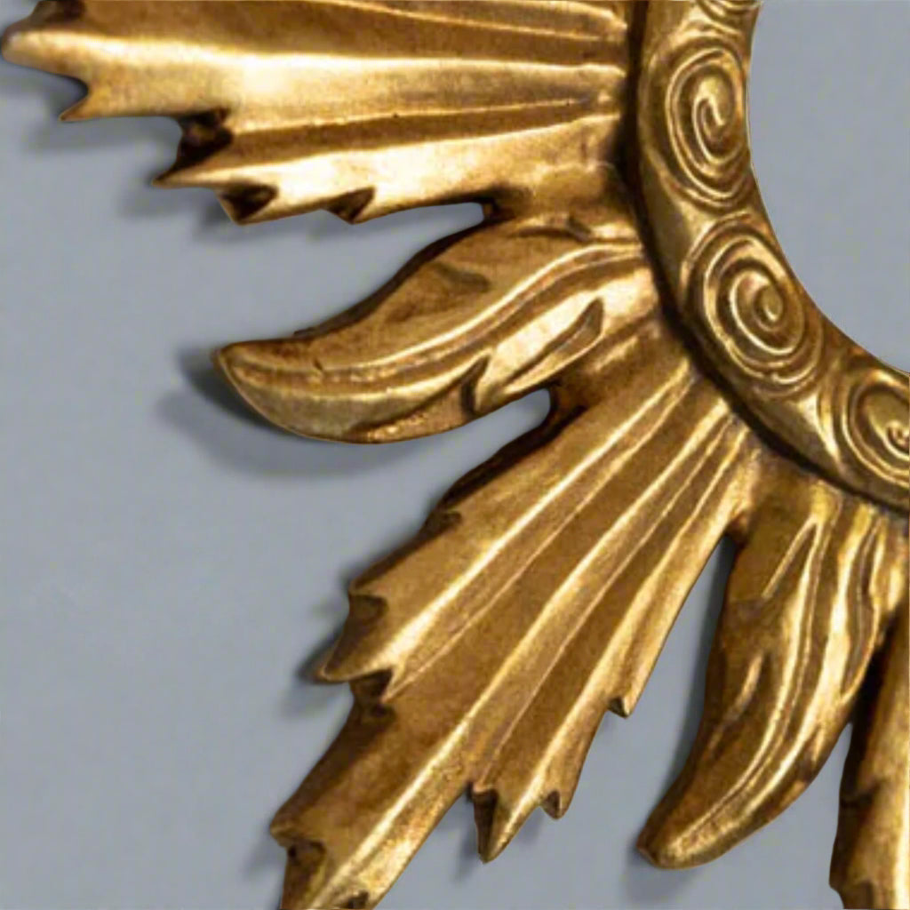 Close-up of a gold decorative element with intricate patterns on a light gray background