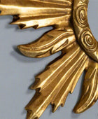 Close-up of a gold decorative element with intricate patterns on a light gray background