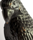 Close-up of a black parrot figurine on a white background