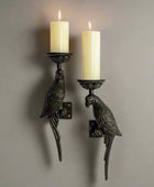 Pair of parrot-shaped wall sconces with candles on a white background