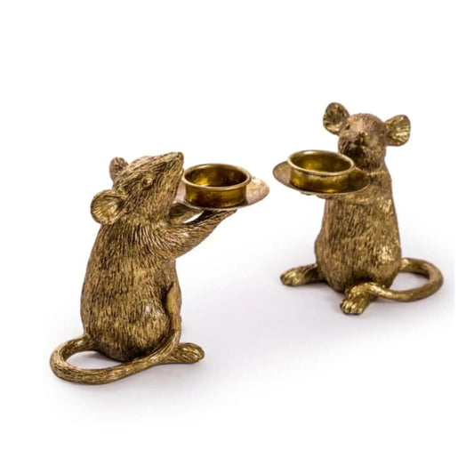 Two brass mouse candle holders on a white background
