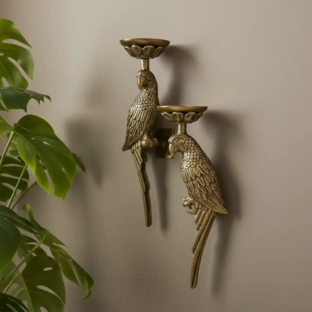 Bronze wall-mounted candle holder with parrot design against a beige wall.