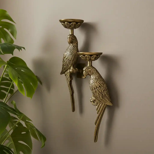 Bronze wall-mounted candle holder with parrot design against a beige wall.