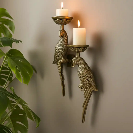 Bronze wall sconce with parrot designs holding candles against a neutral background