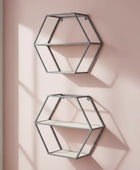 Two geometric wall shelves on a pink wall