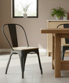 Dining area with wooden table and black metal chairs in a modern kitchen.