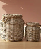 Two wicker baskets on a wooden surface with a pinkish-beige background