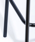 Close-up of a black metal stool on a white background