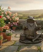 Frog statue in a garden with potted plants and a scenic background