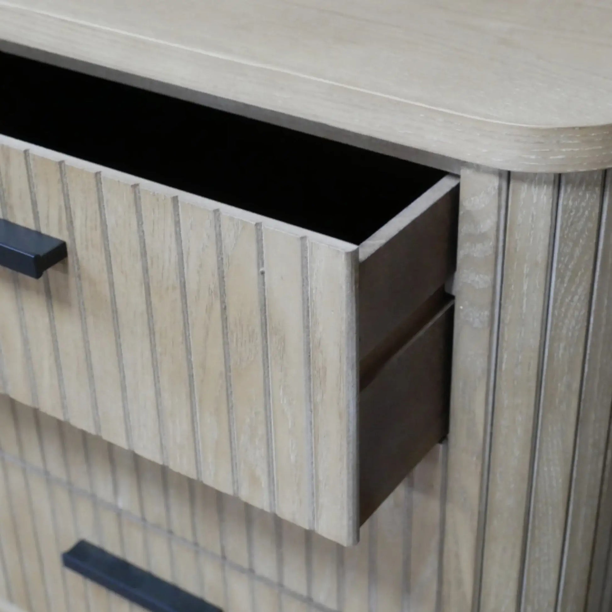 Wooden cabinet with open drawer and black handles