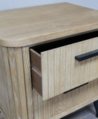 Wooden side table with two drawers and black handles on a light background