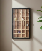 Wall-mounted wooden shelf with decorative items against a neutral wall with a plant on the right.