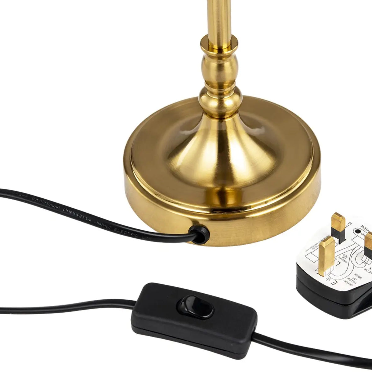 A close-up of a table lamp base in polished gold, with a black power cord, inline switch, and UK three-pin plug on a white background.