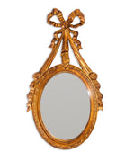 Decorative gold mirror with a bow-shaped design on a white background