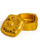 A small metallic gold keepsake box with a hinged lid featuring an embossed Sacred Heart design, shown open on a plain white background.