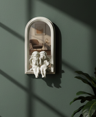 Decorative wall mirror with classical sculpture on a green wall