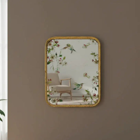 Decorative mirror with floral and bird design on a wall