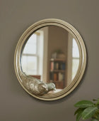 Round mirror with gold frame on a brick wall