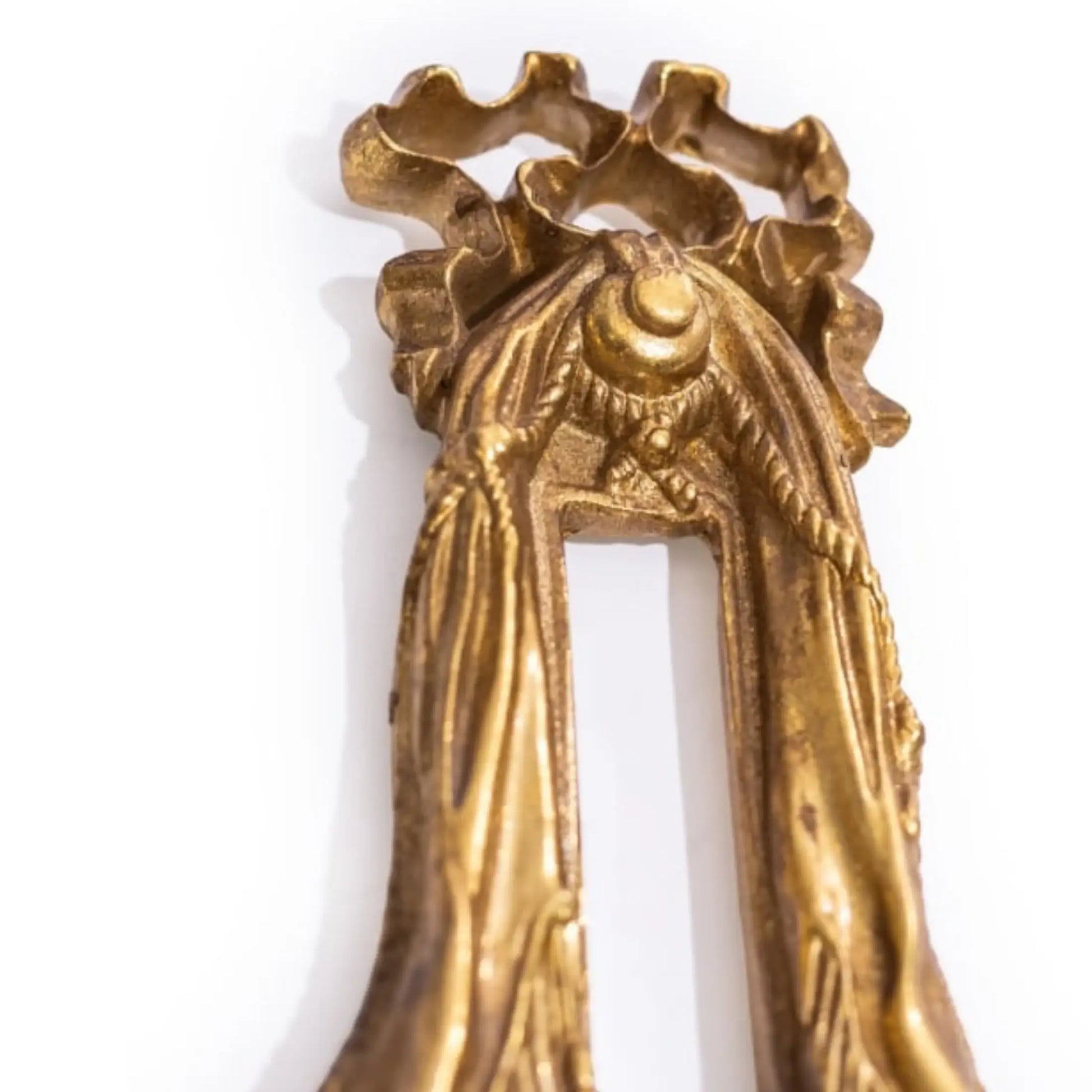 Decorative gold keychain with intricate design on a white background