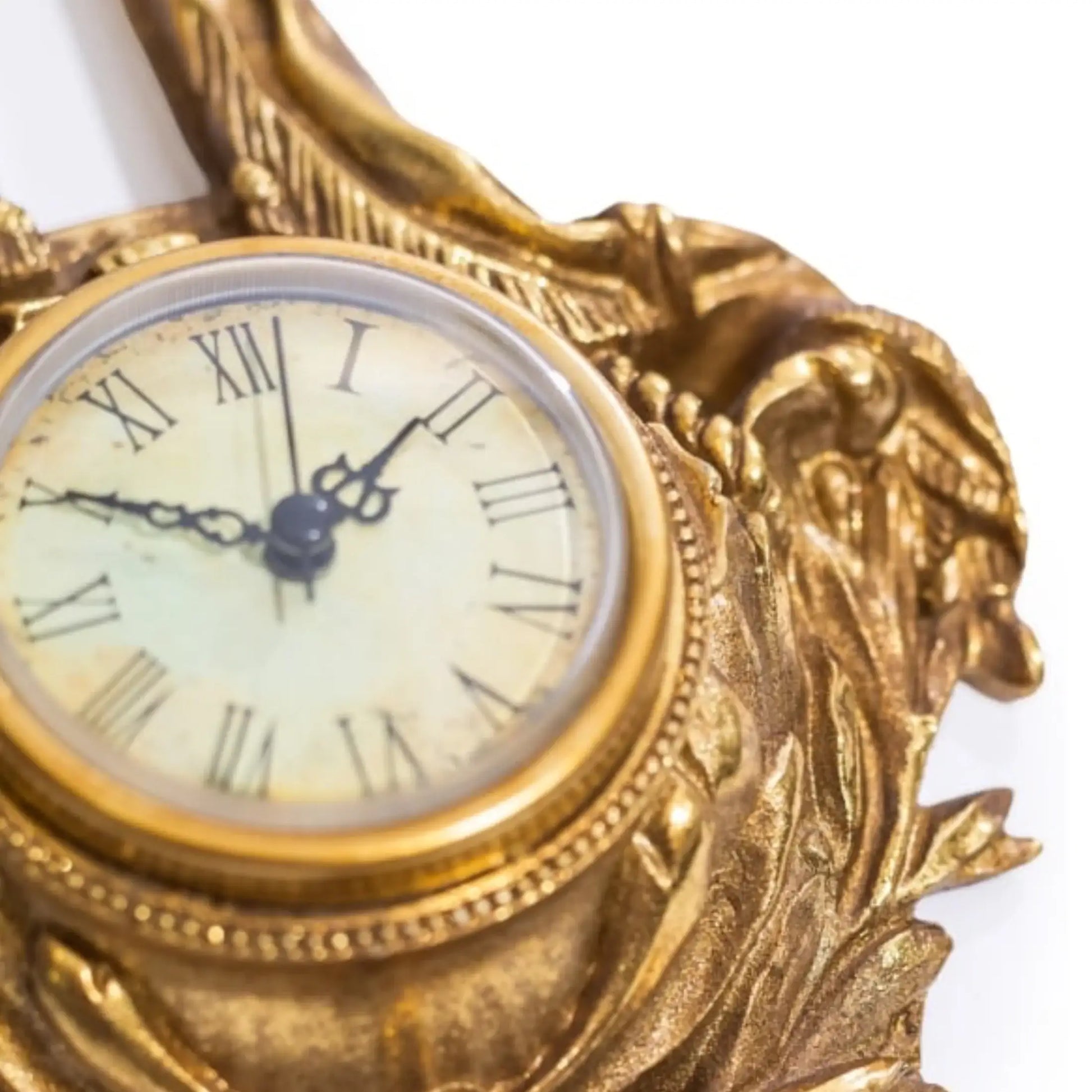 Decorative gold clock with intricate designs on a white background