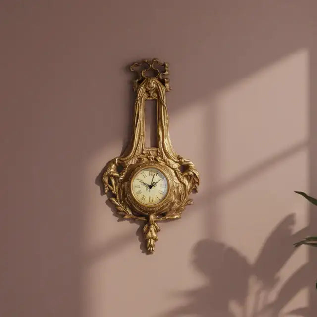 Decorative gold wall clock on a pink wall with plant shadows