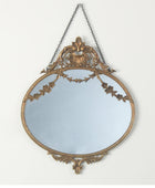 Decorative wall mirror with gold frame and chain on a white background