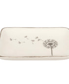 A rectangular ceramic dish with rounded corners, featuring a dandelion design in gray on an off-white background, with a metallic gold-toned rim.