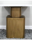 Close-up of a table with a gold metal base on a gray carpet.