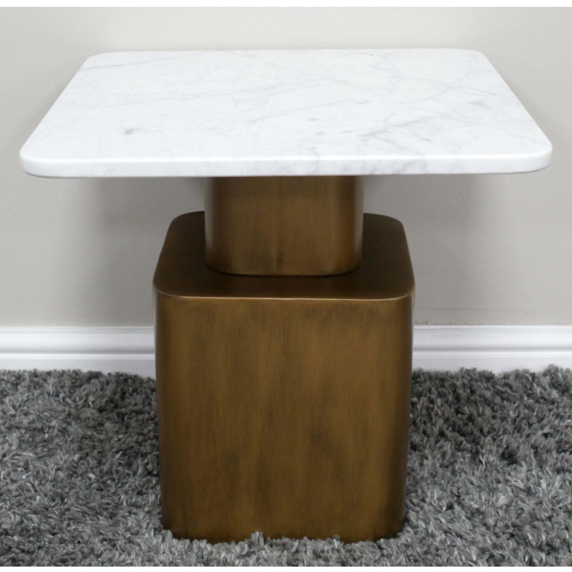 Small table with marble top and bronze base on a gray carpet