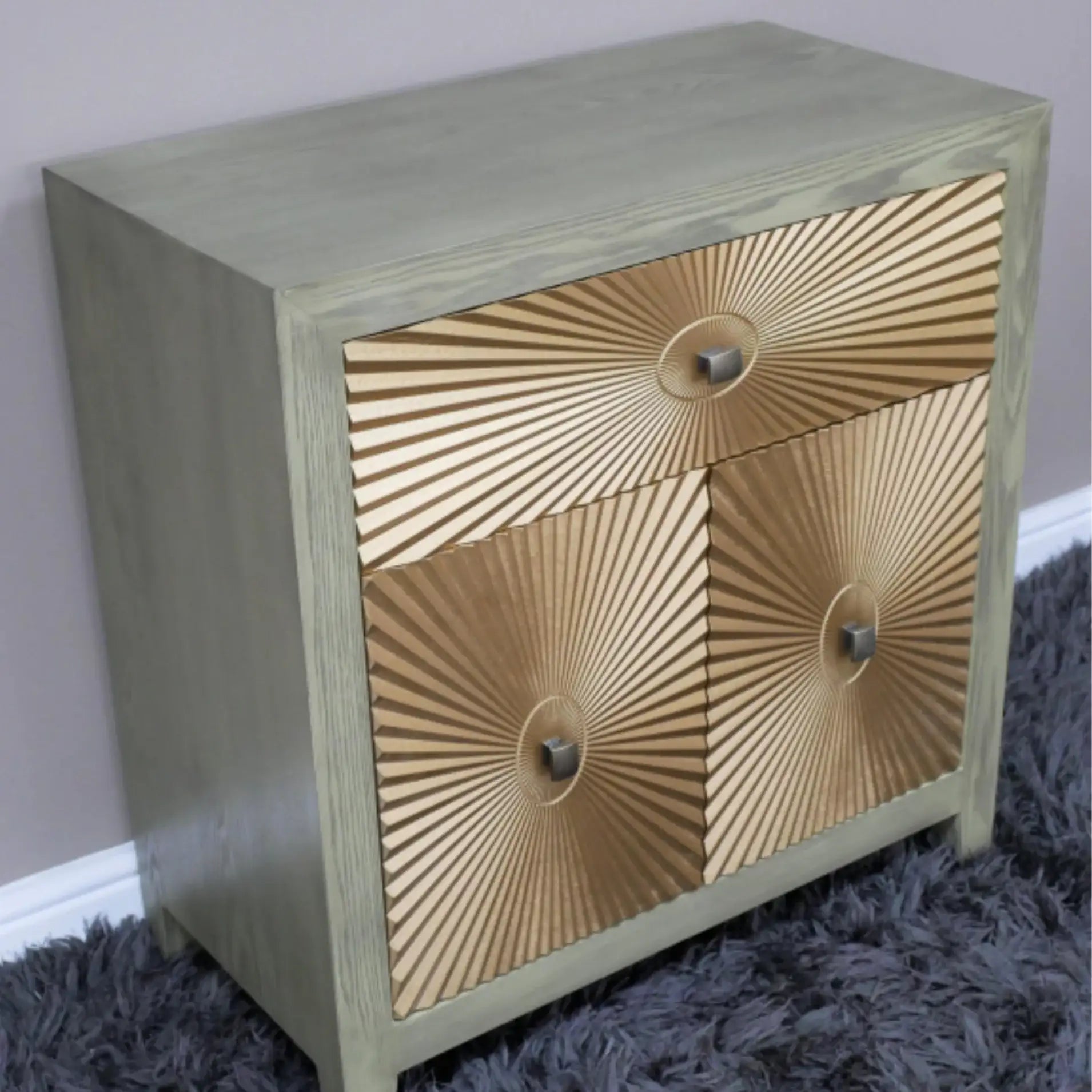 Wooden side table with gold sunburst design on a gray carpet