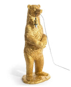 Gold bear-shaped lamp with a light bulb on a white background