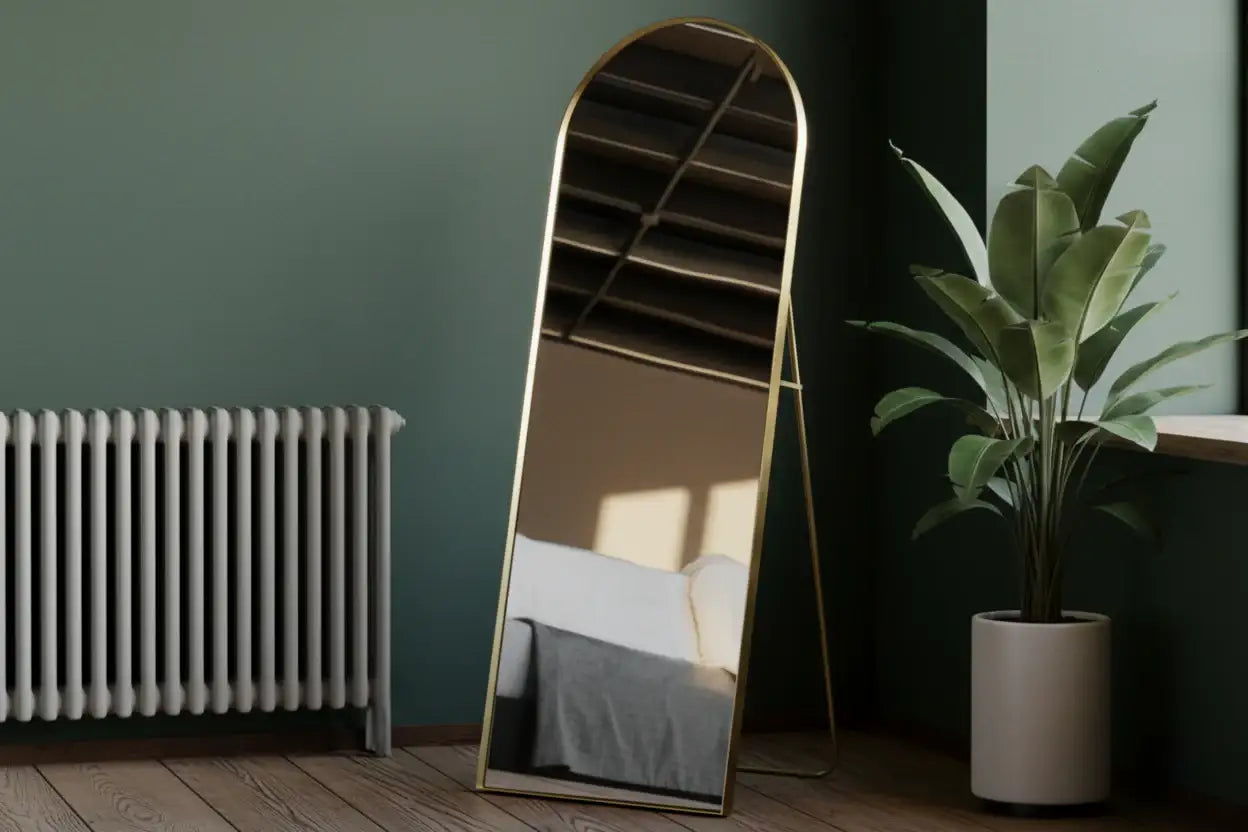 Arched floor mirror with gold frame in a room setting