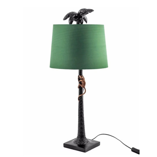 Table lamp with green shade and turtle design on a white background
