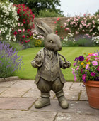 Statue of a rabbit in a garden with flowers and lavender