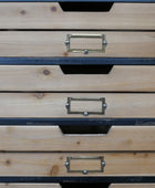 Stack of wooden drawers with metal handles on a plain background
