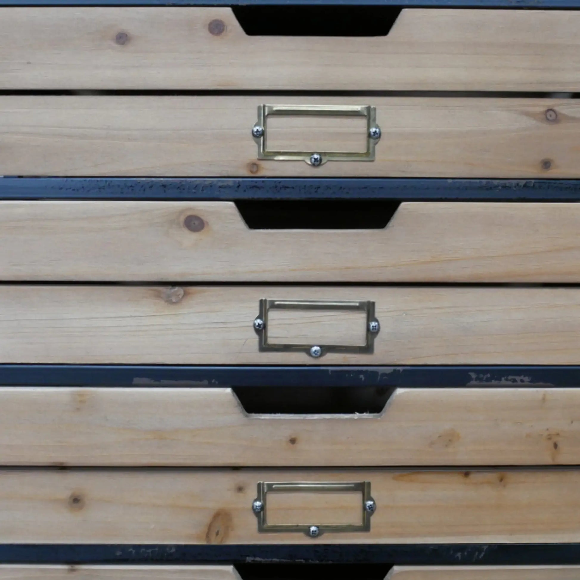 Stack of wooden drawers with metal handles on a plain background